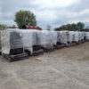 Large bags of firewood on pallets covered with plastic sheets